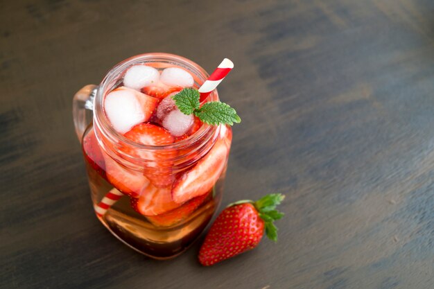 Refreshing strawberry lemonade on a brown background.