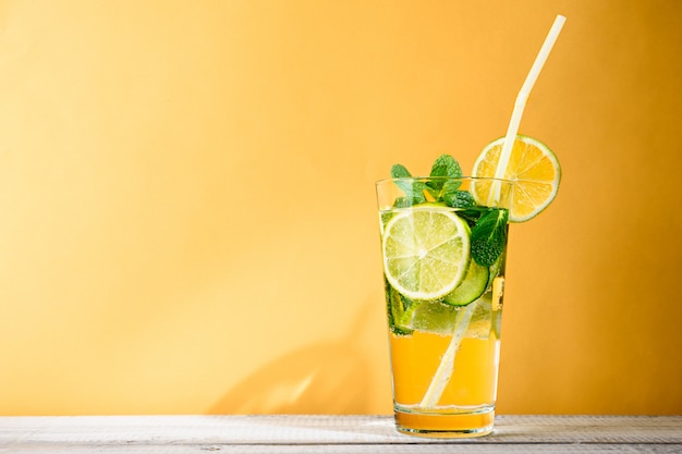 Refreshing summer cocktail on yellow background