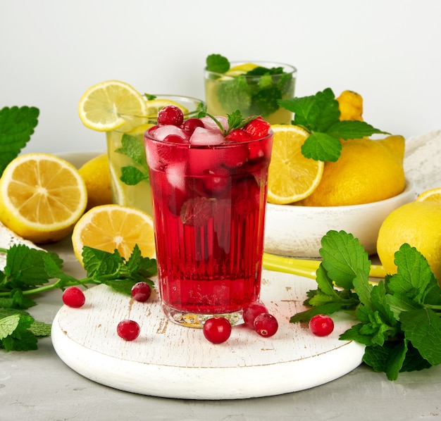 Refreshing summer drink of strawberries and cranberries on a white wooden board