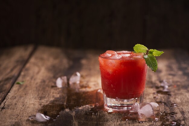 Refreshing summer watermelon juice in glasses on wooden table.