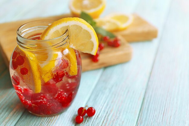 Photo refreshing water with fruits on table