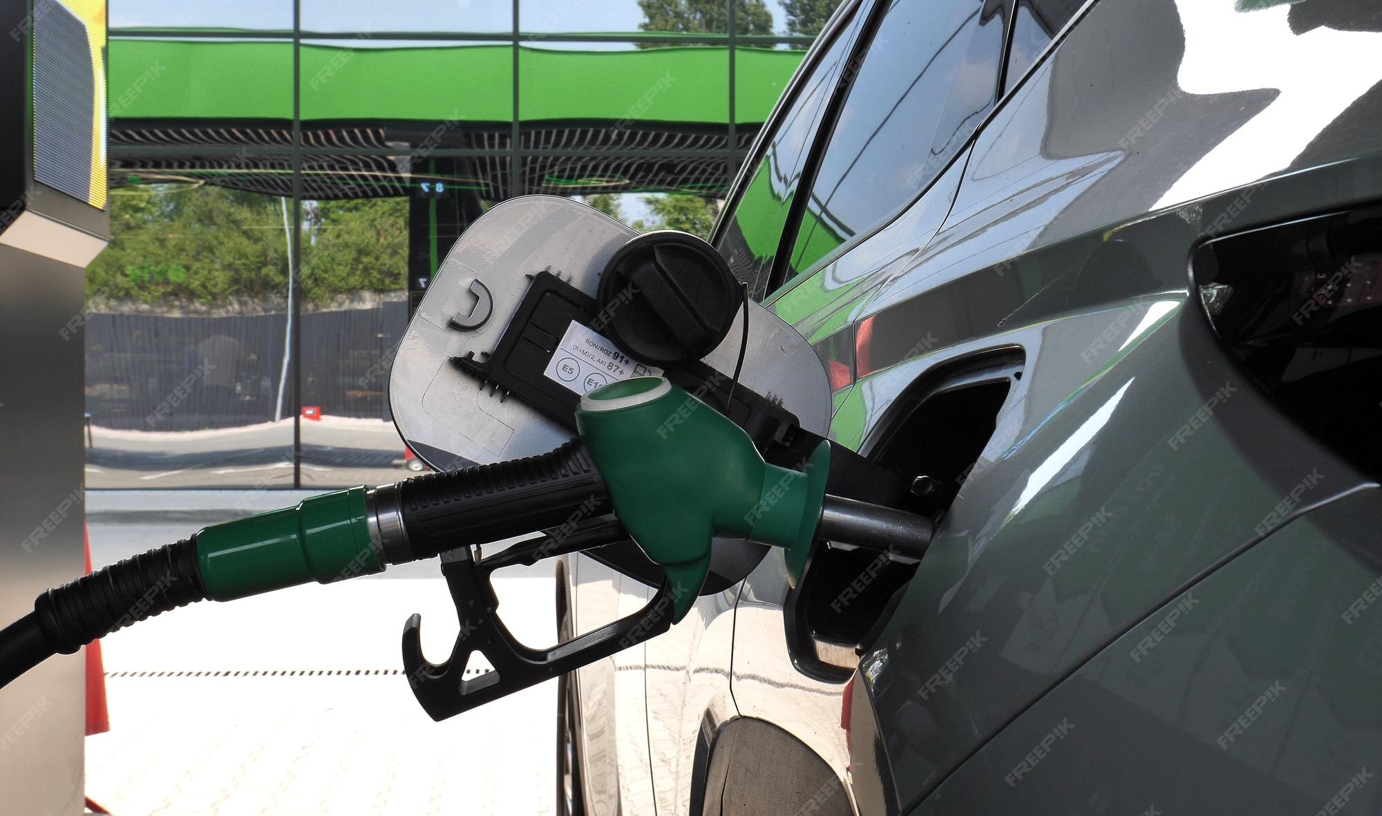 Premium Photo Refueling nozzle inserted into the car gas tank neck