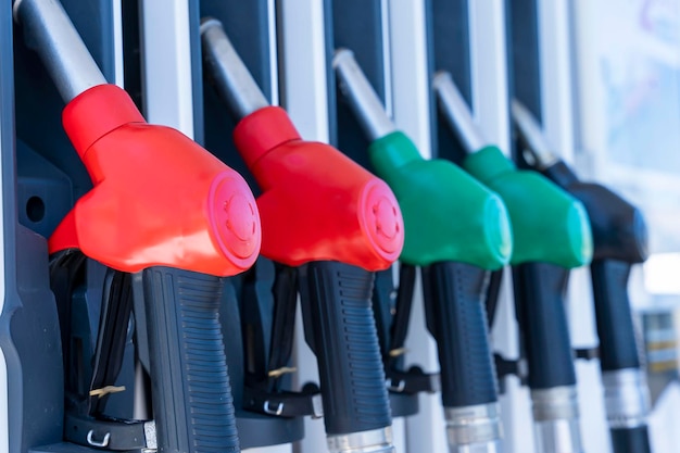 Photo refueling pistols hang in a row at a gas station side view from below