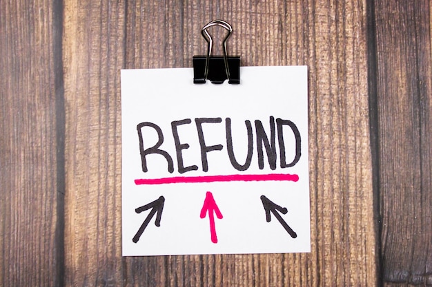 REFUND text and arrows on a sheet on a wooden table