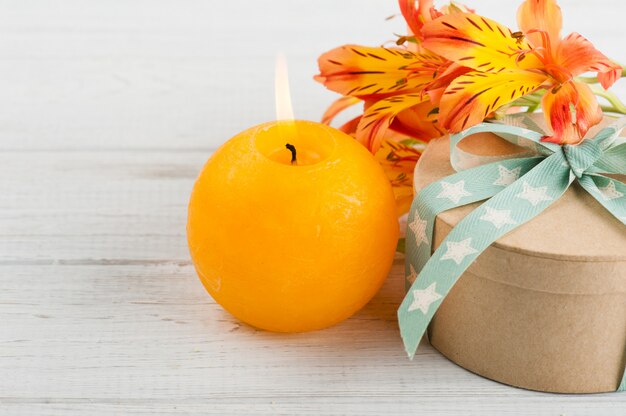 Regeling van oranje lelie bloemen en kaars, geschenkdoos