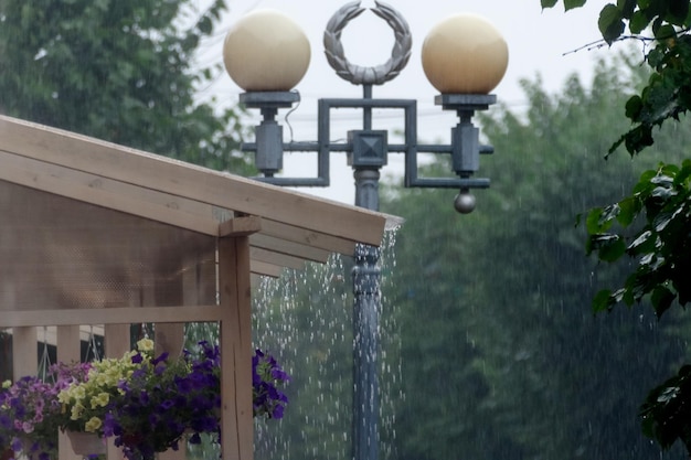 Regen druppelt van het dak van een zomercafé