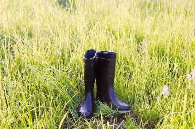 Foto regen rubberen laarzen op groen gras