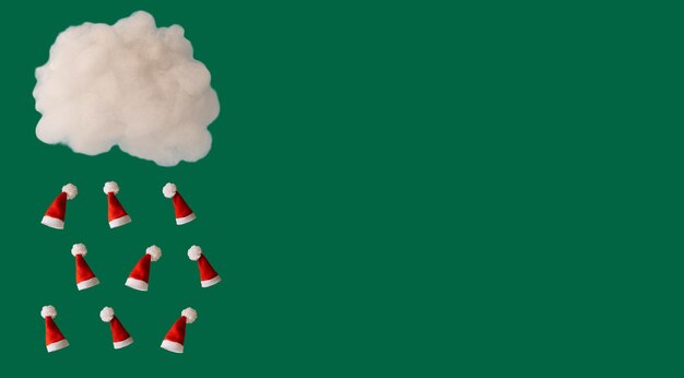 Regen van kerstrode doppen van een witte wolk op een groene achtergrond, een nieuwjaarsconcept met vrije ruimte voor tekst