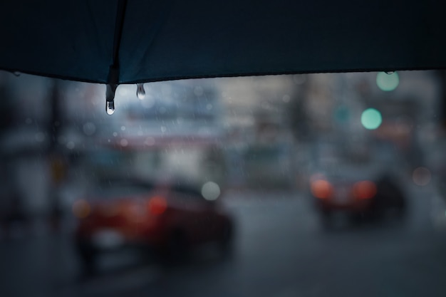 Regenachtige dag in de stad met blauwe paraplu. Stadsleven met zachte focus en zeer ondiepe scherptediepte.