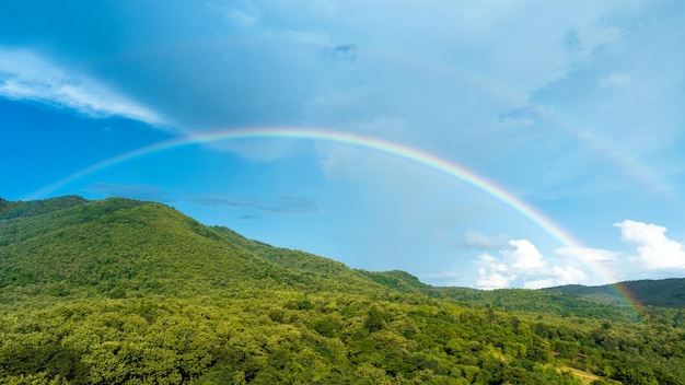 Regenboog op lucht in de bergen Panorama van vliegen in een natuurregenboog in de regen Luchtfoto van regenboog in berg Regenboog in de bergen Puffy Clouds After the Rain