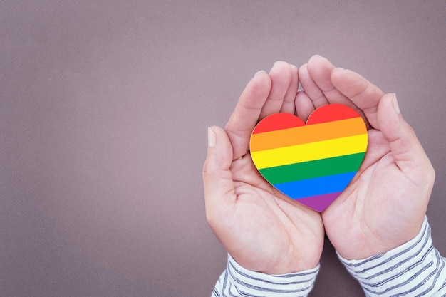 Regenboogharten symboliseren homo- en LGBT-trots op een menselijke hand Concept van ondersteuning van menselijke relaties