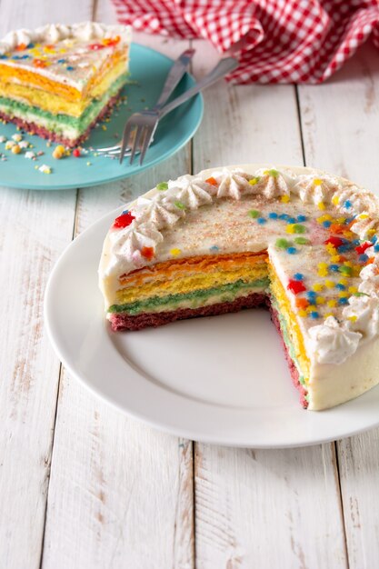 Foto regenbooglaagcake op witte houten tafel