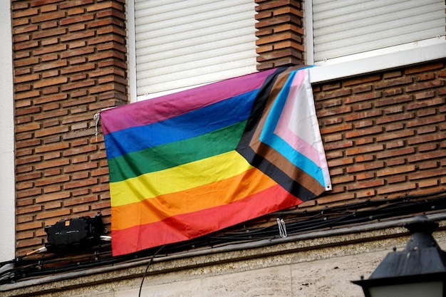 Regenboogvlaggen op de balkons van een huis en op mensenhanden