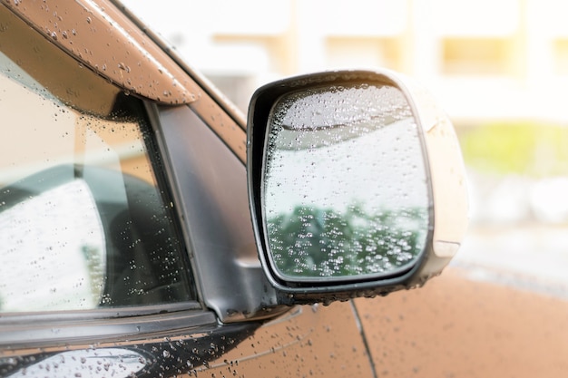 Regendruppels op de zijspiegel van de auto nadat de regen is gestopt.