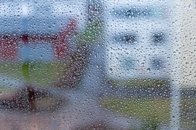 Regendruppels op glas op een wazige achtergrond regen op het raam druipende regen op het raam foto