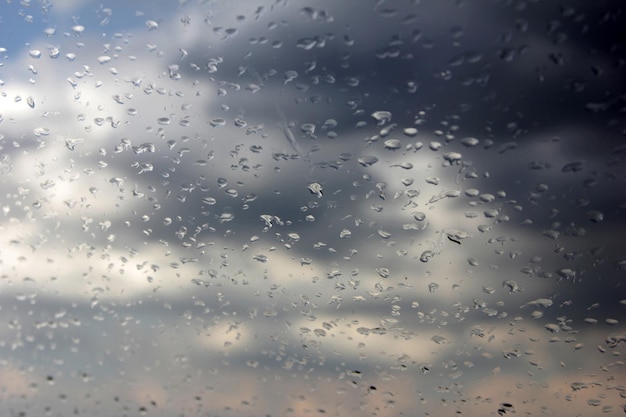 Regendruppels op het glas en onweerswolken in de lucht