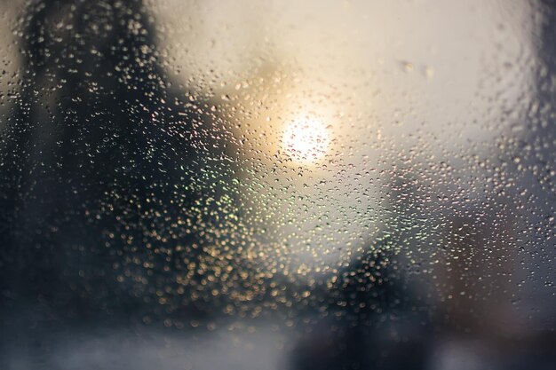 Regendruppels op het oppervlak van het autoglas bij regenachtig weer met een onscherpe achtergrond