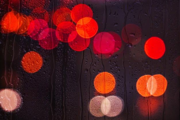 regendruppels op het raam in regenachtige dagen en straatverlichting achtergrond