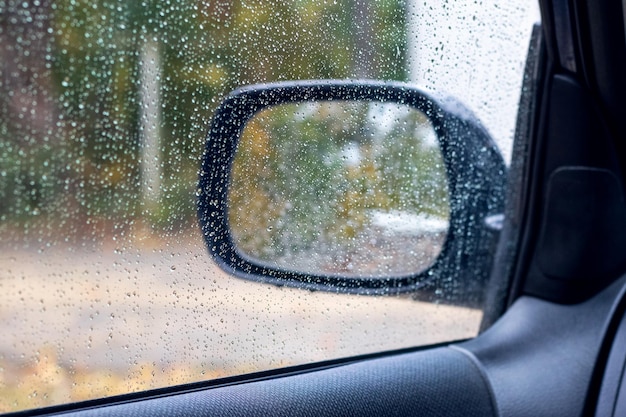 Regendruppels op het raam van de auto regenachtige herfst weer