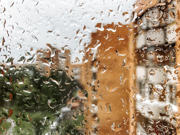 Regendruppels op vensterglas in regenachtige dag