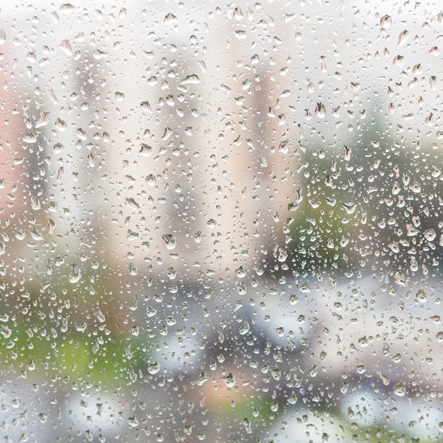 Regendruppels op vensterglas van flatgebouw