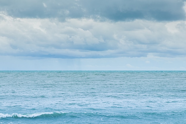 Regenwolken die op zee in de hemel drijven