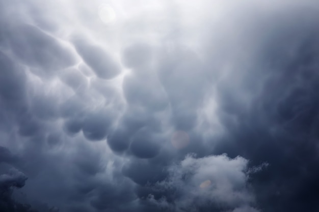 Regenwolken in de lucht. Grijze donkere wolken in de lucht. Onweerswolk