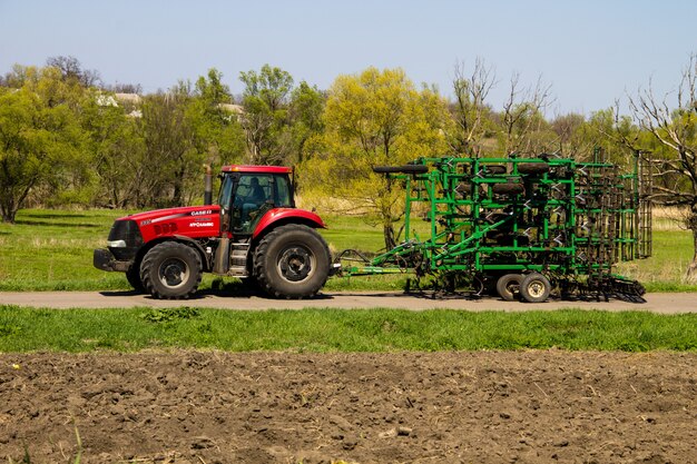 Regio Kirovograd, Oekraïne - 26 april 2017: Trekker met cultivator op de landelijke weg