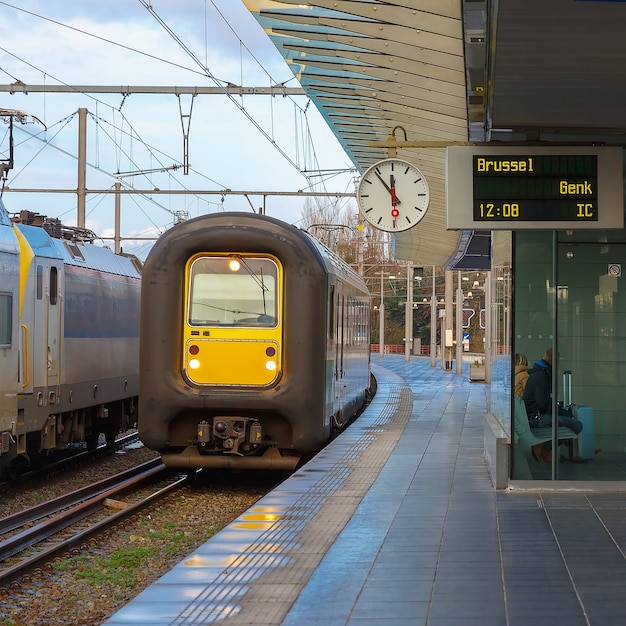 Regional Train in the station Bruges with clock