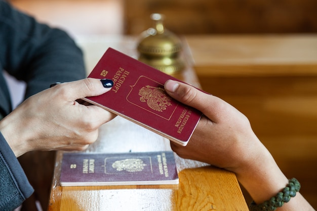 Registratie van toeristen in het hotel, paspoort bij houten receptie