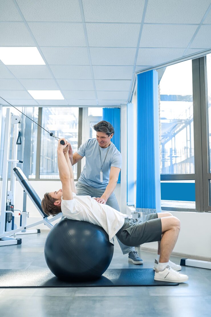 Foto rehabilitatie-oefeningen mannelijke patiënt die een rehabilitatie-oefening doet op een fitball