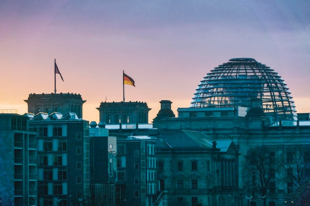 Reichstag en gebouwen in de stad bij zonsondergang