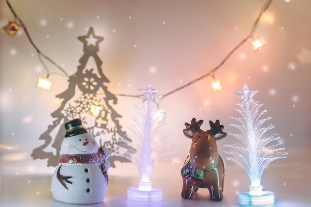 Reindeer and Snowman stand near christmas tree. Merry Christmas and happy new year