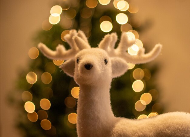 Reindeer with christmas tree in background shining lights golden