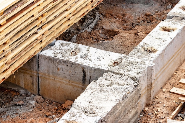 Reinforced concrete foundation of a modern monolithic residential building Prepared formwork with reinforcing mesh for pouring concrete Dirt and clay at the construction site