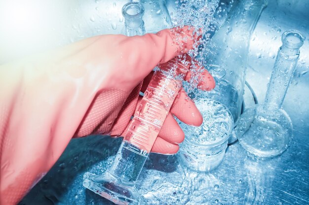 Reinig het chemische glas in het laboratorium met een handschoen.