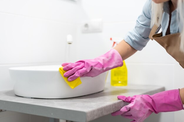 Reiniging - gootsteen in de badkamer schoonmaken met wasmiddel - huishoudelijk werk, lenteschoonmaakconcept