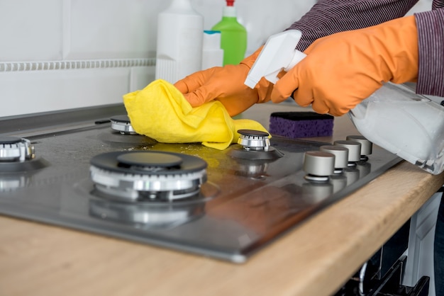 Reiniging in de keuken gassteen met schuim en spons. Huishoudelijke apparatuur voor een gezonde levensstijl