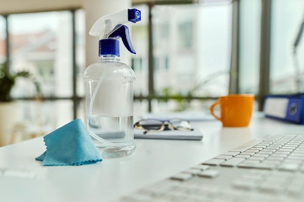 Foto reinigingssprayfles en een doek op een bureau op kantoor