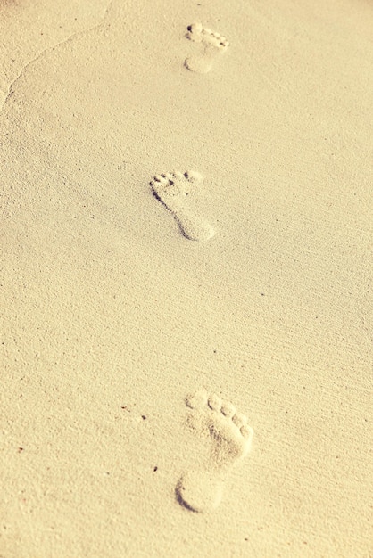 reis-, avontuur- en strandconcept - voetafdrukken op zand