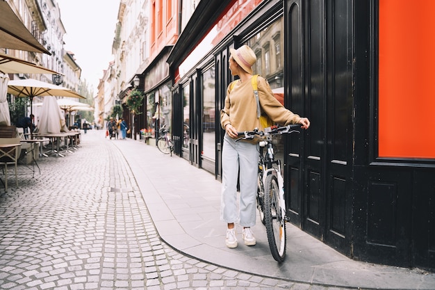 Reis door Europa meisje met rugzak en stadsfiets in de oude straat in het historische centrum van Ljubljana