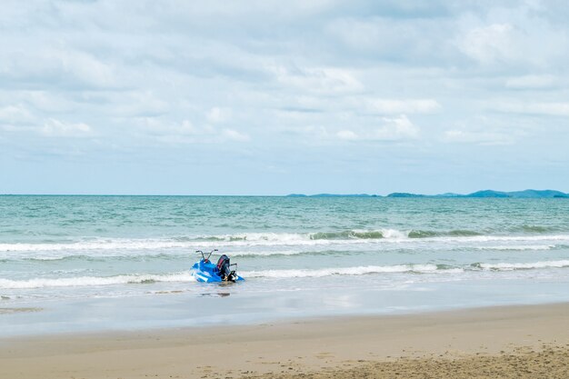 Reis in de natuur op een strand en tropische zee met blauwe lucht en neem een ​​retro water scooter