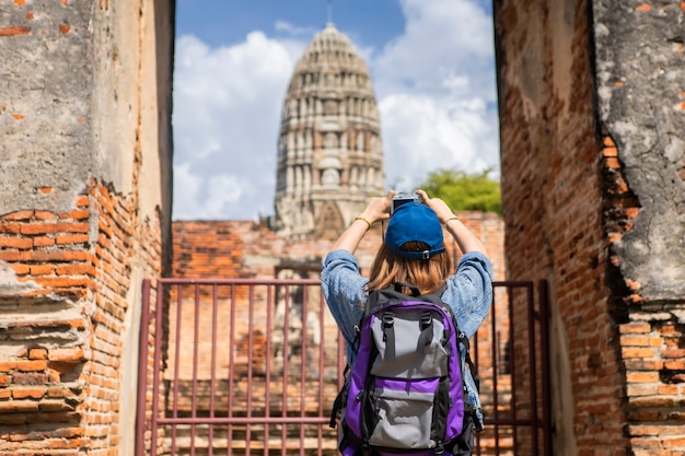 Reis in de tempel van Thailand, Ayutthaya. Toeristen Aziatische vrouwen die camera met het Dragen van een rugzak houden.