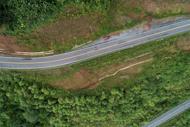 Reis op heuvelachtige weg in het voorjaar luchtfoto wegcurve constructie tot aan de berg Verbazingwekkend top-down beeld van drone camera.