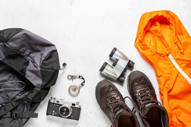 Reis rugzak, kompas, laarzen, jas, camera en verrekijker op een witte achtergrond. Concept wandeling, toerisme, kamp. Banner. Plat lag, bovenaanzicht