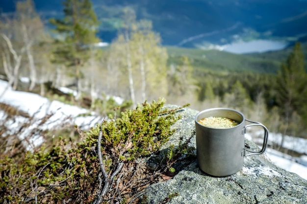 Reisbeker van titanium. Lunch tijdens de reis naar het wild. Camping levensstijl.