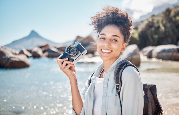 Reisstrand en camera met een zwarte toerist die een foto maakt aan zee of oceaanwater in de zomer Natuurportret of fotograaf met een vrouw buiten op vakantie of vakantie aan de kust