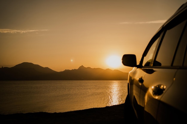 Reistoerisme met de auto in de bergen de zonsondergang de achtergrond van hoge heuvels panoramisch uitzicht