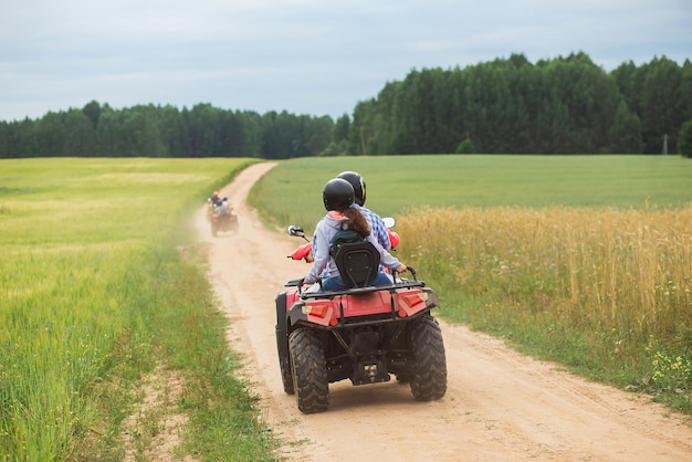 Reistour op qad-fietsen in de prachtige tarweveldwegen Paar rijden in ATV-achteraanzicht