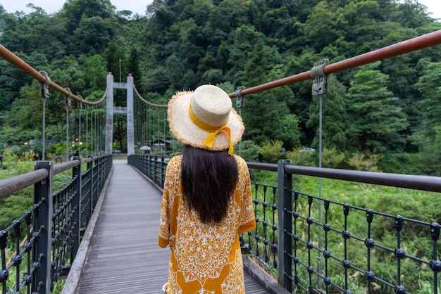 Reisvrouw loopt in de houten hangbrug